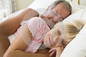 Couple lying in bed sleeping