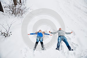 Couple Lying On Snow Making Snow Angel. Winter vacation