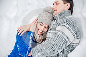 Couple lying on snow in winter park. Winter vacation