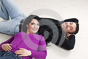 Couple lying on wooden floor