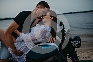 Couple makes love on beach lying on motorcycle