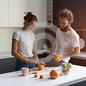 Couple making fun cooking together at modern kitchen in a new house. Beautiful young couple happy of their new home