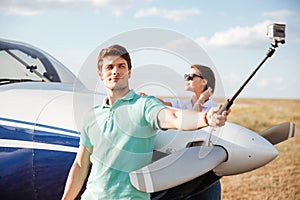 Couple making selfie standing near plane
