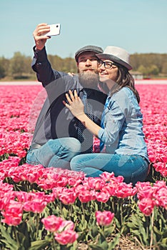 Couple making selfie in a tulip field