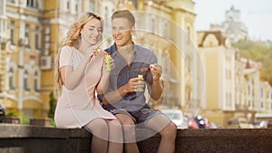 Couple making soap bubbles, romantic relationship of young people dating