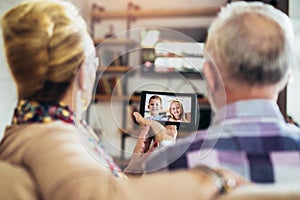 Couple making video call on digital tablet with their grandchildren.Quarantine. Health concept