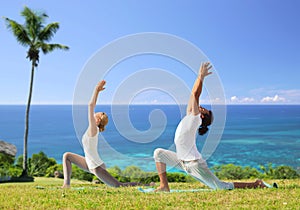 Couple making yoga in low lunge pose outdoors