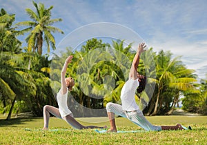 Couple making yoga in low lunge pose outdoors