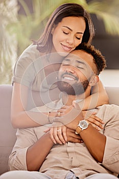 Couple, man and black woman on sofa for hug, love and care in living room to relax while happy. Black man, woman and