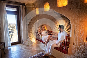 A couple man and woman drinking wine in the old cave room of Cappadocia