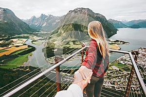 Couple Man and Woman follow holding hands in Norway mountains