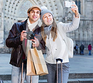 Couple man and woman in the historic center with camera and phone