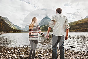 Couple man and woman holding hands enjoying mountains and lake view