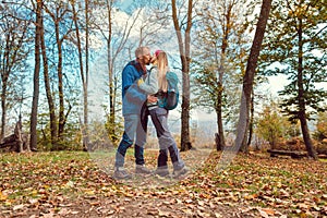 Couple of man and woman kissing during walk in fall photo