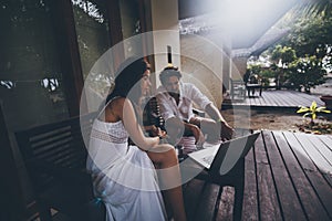 Couple: man and woman with laptop on veranda