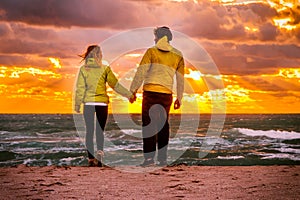 Couple Man and Woman in Love walking on Beach seaside holding hand in hand