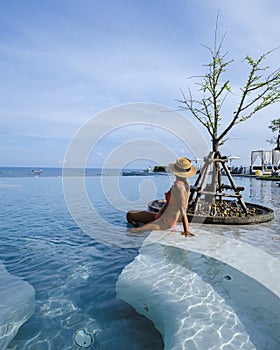couple man and woman on a luxury vacation enjoying the infinity pool on the rooftop, Pattaya Thailand.