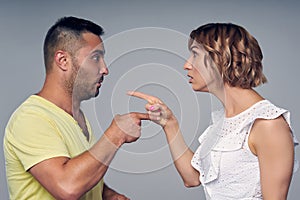 A couple man and woman pointing at each other expressing accusation photo