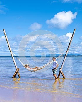 couple man and woman relaxing in hammock on the beach in Phuket Nai yang beach Thailand