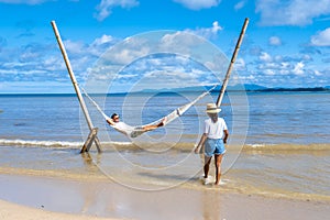 couple man and woman relaxing in hammock on the beach in Phuket Nai yang beach Thailand