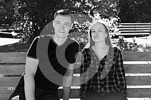 couple man and woman sitting on bench. with a pensive and anxious look forward.