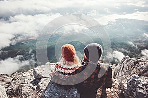 Couple Man and Woman sitting hugging on cliff