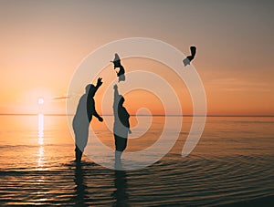 Couple of man and woman standing in the sea and throw your shoes at the beach.