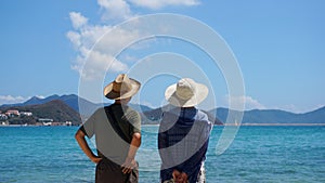 Couple Man and Woman staying on Beach seaside and look away