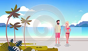 Couple man woman sunrise tropical palm beach summer vacation smiling walking seaside sea ocean flat horizontal