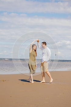 a couple of a man and a woman are walking on the beach or running along the sand along the seashore. beautiful and young