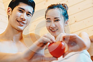 Couple, man and woman were sitting and drinking wine in the sauna