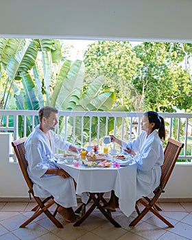 couple man and woman mid age having breakfast on their balcony of an appartment luxury hotel condo in Mauritius