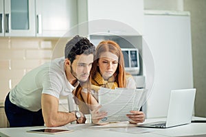 Couple managing finances, reviewing bank accounts using laptop computer