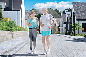 Couple of mature businessmen feeling amazing while jogging together