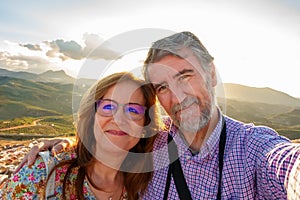 Couple of mature man and woman taking a selfie on a tourist trip in early retirement.