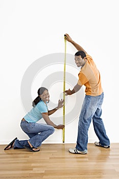 Couple measuring wall.