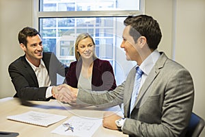 Couple meeting with financial adviser, handshake