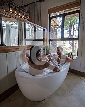 couple men and woman in bathtub on a luxury safary,South Africa, luxury safari lodge in the bush