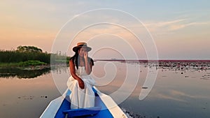 a couple of men and woman in a boat at sunrise at the Red Lotus Lake in the Isaan