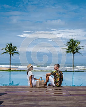 couple men and woman relaxing by the pool during a luxury vacation in Thailand