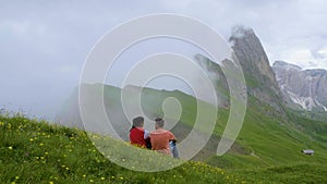 A couple of men and a woman visit the Dolomites Alps. Odle mountain range Seceda peak