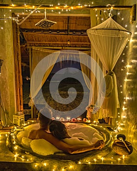 a couple of men and women in a bathtub with Christmas lights on the countryside of Nan Thailand