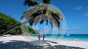 Couple of men and women on the beach of Anse Lazio beach Praslin island Seychelles,