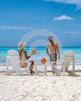 couple men and women on the beach with coconut drink, Praslin Seychelles tropical island