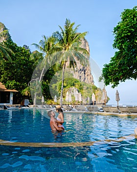 couple of men and women at a swimming pool of a luxury resort in Thailand