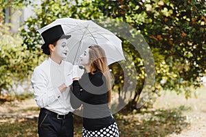 A couple of merry mimes. He hurries on a date