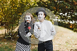 A couple of merry mimes. He hurries on a date