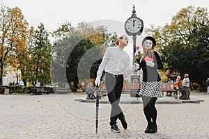 A couple of merry mimes. He hurries on a date