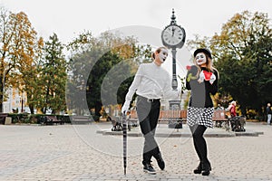 A couple of merry mimes. He hurries on a date
