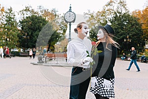 A couple of merry mimes. He hurries on a date